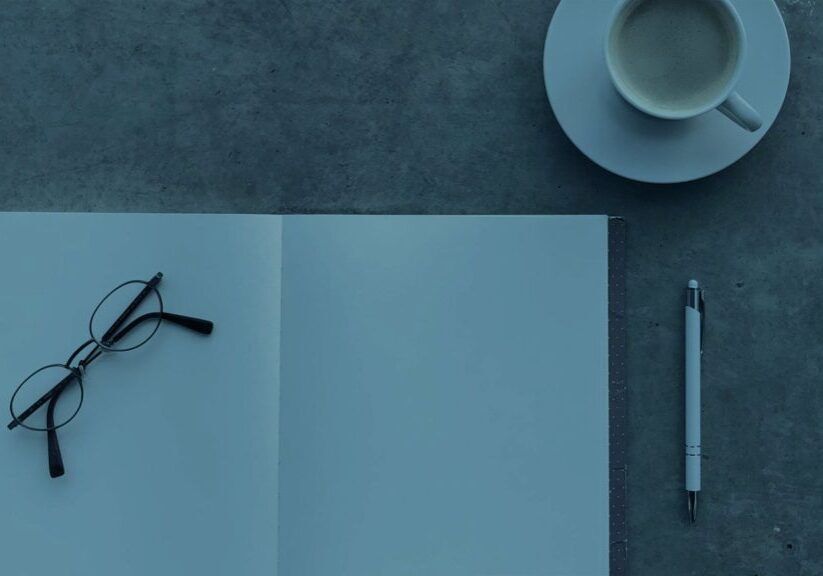 Notepad with reading glasses pen and coffee