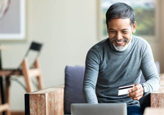 A man makes a purchase online while spending safely