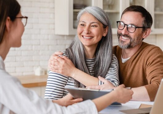 Successful positive deal. Lawyer financial advisor helping consulting showing contract mortgage loan credit business startup, signing documents by matute middle-aged couple at home