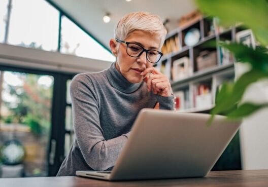 Senior woman looks at her laptop